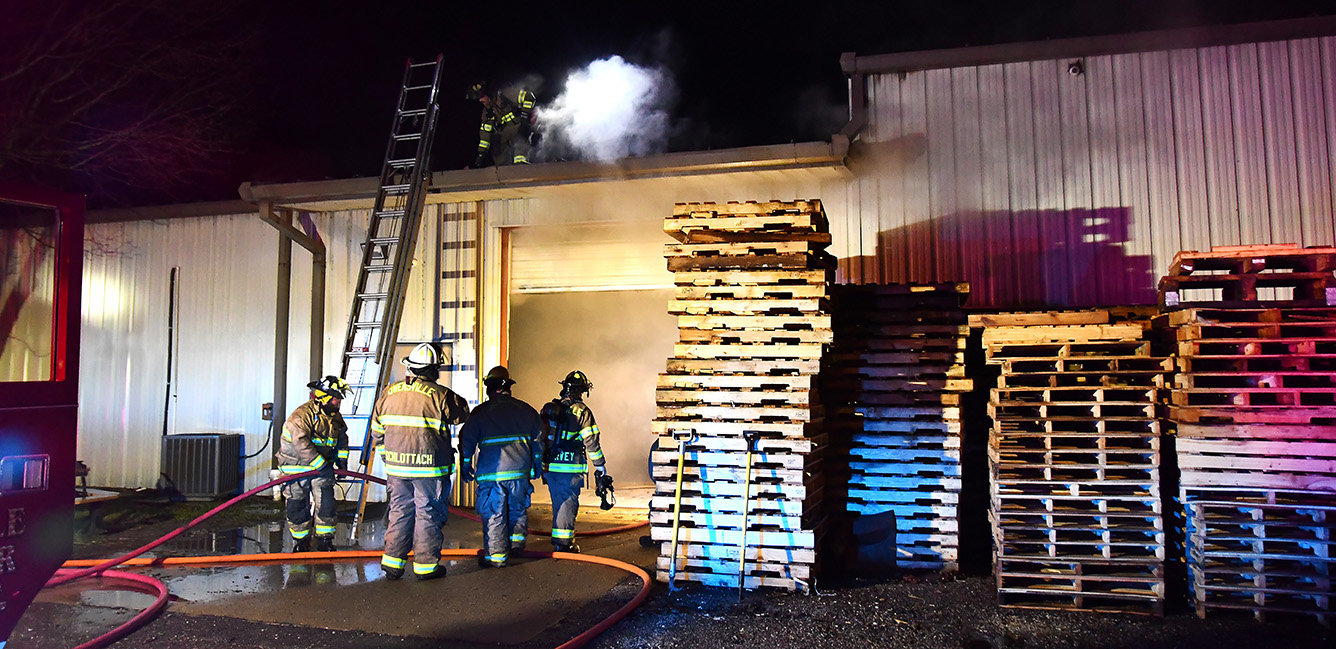 Firemen ventilate the roof on the east end of The Toolroom on Monday night during the initial efforts to contain a fire of undetermined origin to that end of the building.